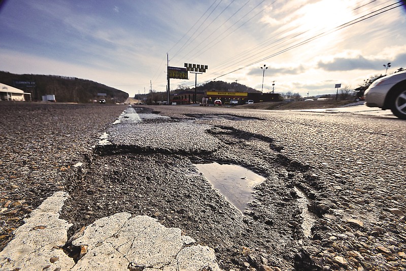 Damaged pavement and potholes create obstacles for southbound motorists in the left lane on Dayton Pike at state Highway 153.