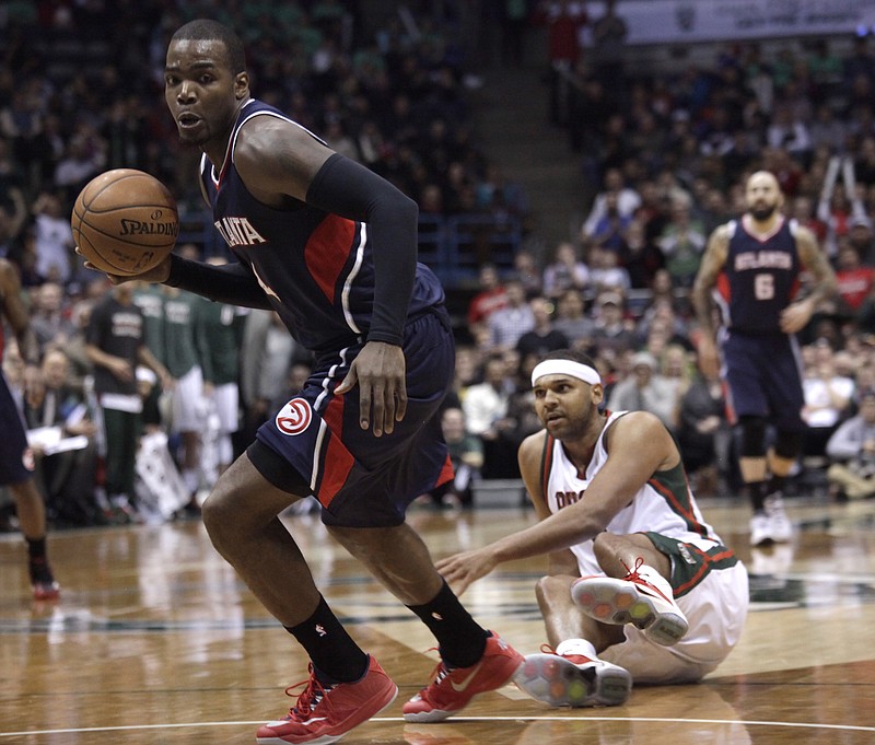Atlanta Hawks forward Paul Millsap drives to the basket in front of Milwaukee Bucks guard Jared Dudley, right, during their game Sunday, Feb. 22, 2015, in Milwaukee. 