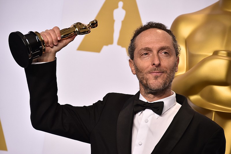 Emmanuel Lubezki poses in the press room with his award for best cinematography for his work on "Birdman" at the Oscars on Sunday, Feb. 22, 2015, at the Dolby Theatre in Los Angeles. 