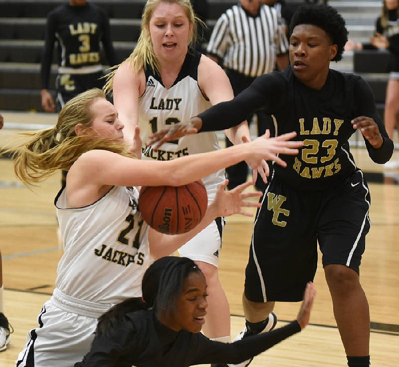 Washington County's Daknequa White (23), top right, reaches in as Calhoun's Jana Johns (21) attempts to get control of a loose ball early in a 51-45 Lady Jackets overtime win Monday at Calhoun. Washington County's Daavaneck Brookins (12) looses her footing, below, and Calhoun's Kyleigh Carrey (12), top, moves in to help. It was the second round of the Georgia state basketball tournament.