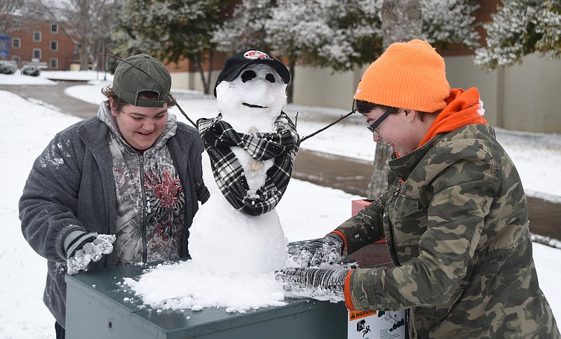 Kym Hardy, left, and Chelsea Boelter, sophomores at Lee University, put the finishing touches on a snowman Tuesday at the university in Cleveland, Tenn.