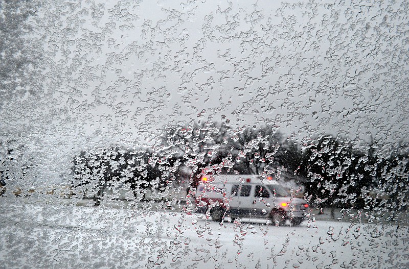 
              An ambulance drives on the snow as seen through a window, Monday, Feb. 23, 2015, in Abilene, Texas. Freezing rain affected travel in nearly half of Texas on Monday, and winter storm warnings were issued in the northern part of the state. (AP Photo/The Abilene Reporter-News, Nellie Doneva)
            