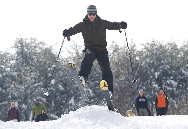 Andrew Graham, 31, launches off of a ski jump he created while having fun in the snow with other area residents at Red Bank's White Oak park on Thursday morning, February 26, 2015. An overnight winter storm dumped over half of a foot of snow on the Tennessee Valley area.