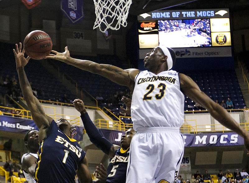 UTC's Tre' McLean, right, tries to rebound over ETSU's Petey McClain (1) and Jalen Riley (5) during their game against the ETSU Buccaneers on Feb. 21, 2015, at McKenzie Arena.