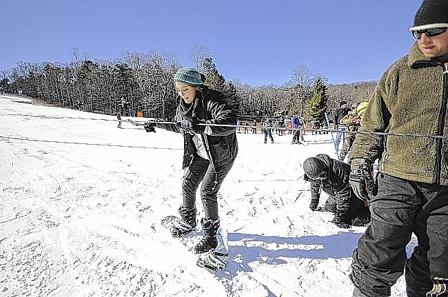 Tabatha Higginbotham, 19, of Birmingham, makes her second attempt at snowboarding at Cloudmont Ski Resort in Mentone, Ala. Employee Chris Rogers gives verbal assistance on using the cable lift.