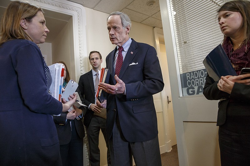 Sen. Tom Carper, D-Del., ranking member on the Homeland Security and Governmental Affairs Committee, center, confers with his staff just before a news conference on Capitol Hill in Washington, Friday, Feb. 27, 2015. 