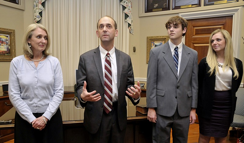 In this Jan. 12, 2015, photo, Tom Schweich, second from left, makes a few comments after his swearing-in ceremony in his Capitol office in Jefferson City.