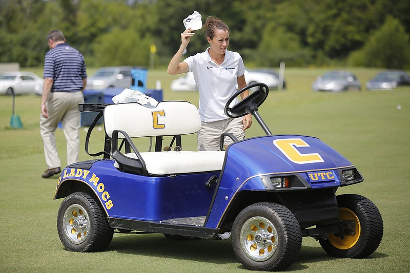 UTC women's golf coach Colette Murray walks past a UTC Lady Mocs golf cart as players practice in this Sept. 9, 2014, photo. 