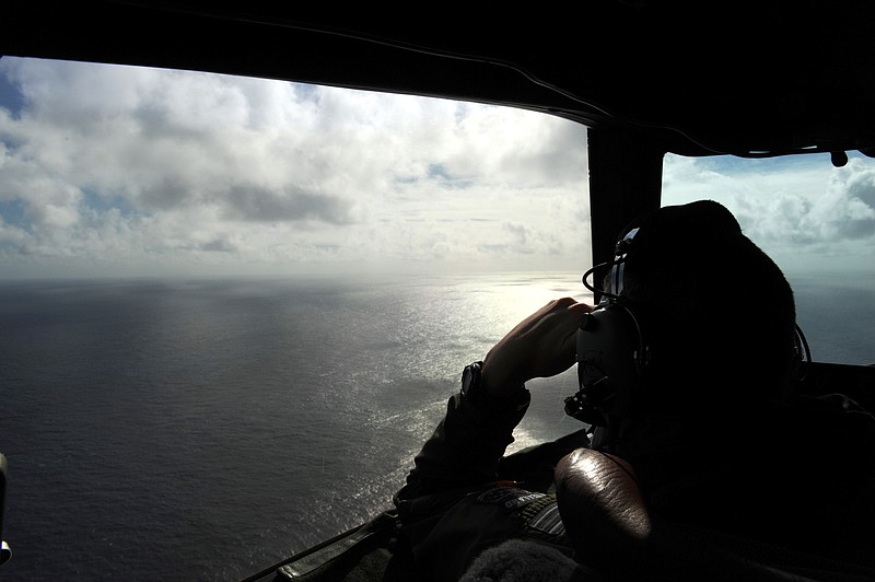 
              FILE - In this April 13, 2014 file photo taken from the Royal New Zealand air force (RNZAF) P-3K2-Orion aircraft, pilot and aircraft captain, Flight Lt. Timothy McAlevey looks out of a window while searching for debris from missing Malaysia Airlines Flight 370, over the Indian Ocean off the coast of western Australia. Australia, Indonesia and Malaysia will lead a trial to enhance the tracking of the aircraft over remote oceans, allowing planes to be more easily found should they vanish like Malaysia Airlines Flight 370, Australia's transport minister said Sunday, March 1, 2015. The announcement comes one week ahead of the anniversary of the disappearance of the flight, which vanished in 2104 on a flight from Kuala Lumpur to Beijing with 239 people on board. No trace of the plane has been found. (AP Photo/Greg Wood, Pool, File)
            