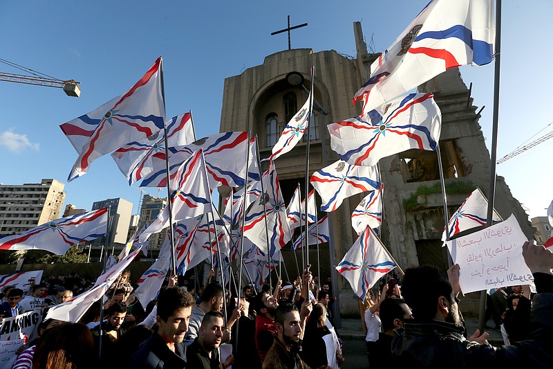 
              Assyrians wave their community's flag, as they march past a church that was damaged during the Lebanese civil war, during a protest in solidarity with Christians abducted in Syria and Iraq by Islamic State militants, in downtown Beirut, Lebanon, Saturday, Feb. 28, 2015. The Islamic State group, which has repeatedly targeted religious minorities in Syria and Iraq, abducted more than 220 Assyrians this week in northeastern Syria. (AP Photo/Hussein Malla)
            