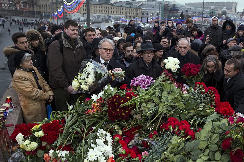 A group of EU ambassadors to Russia lay flowers at the place where Boris Nemtsov, a charismatic Russian opposition leader and sharp critic of President Vladimir Putin, was gunned down, at Red Square, with St. Basil Cathedral in the back and the Kremlin at left, in Moscow, Russia, on Saturday, Feb. 28, 2015. 