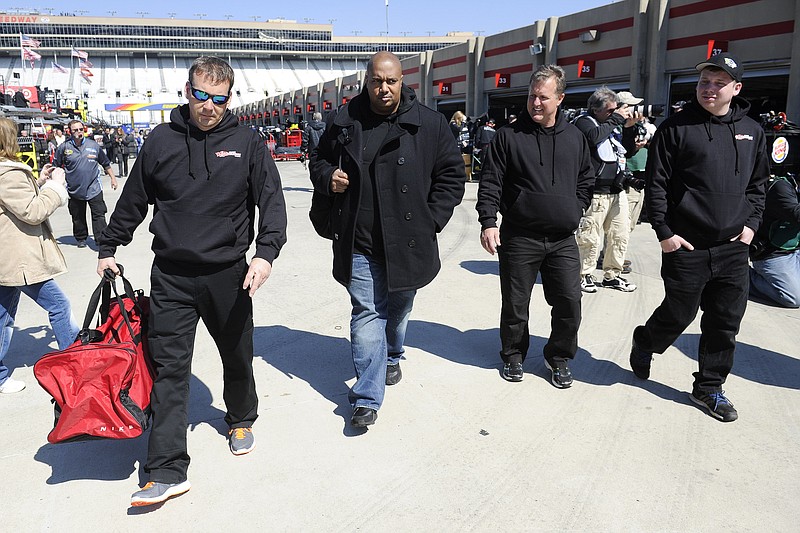 NASCAR driver Travis Kvapil's, not shown, crew members including owner John Cohen, second from left, leave the garage at Atlanta Motor Speedway on Feb. 27, 2015, in Hampton, Ga. Kvapil's NASCAR Sprint Cup car was stolen early Friday, forcing him to withdraw from a race this weekend. A trailer with the red No. 44 car inside was hitched to a black 2004 Ford F-350 pickup truck parked outside a hotel in Morrow, Georgia, about 15 miles south of Atlanta, police said.