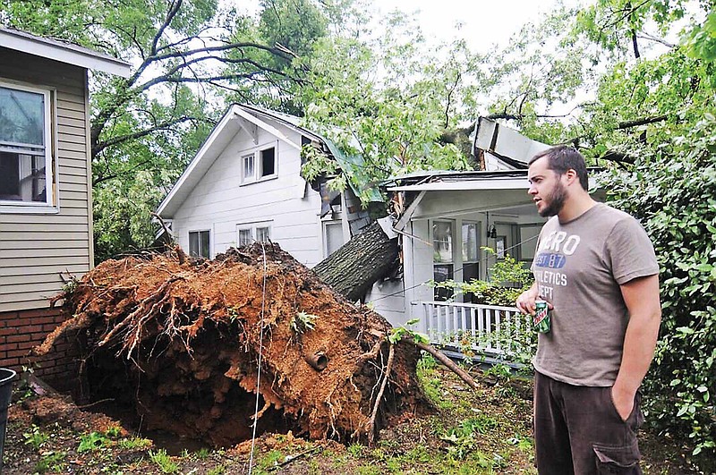 Jimmy Hibbs looks at a tree that fell from his Crewdson Avenue yard onto Dennis Plumlee's house in the 2011 storm. 