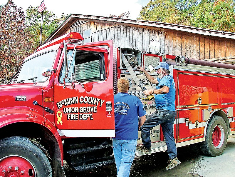 Union Grove Fire Chief Alvin Shomake and firefighter Andy Ward check
hose on trucks at the rural District 9 fire department.