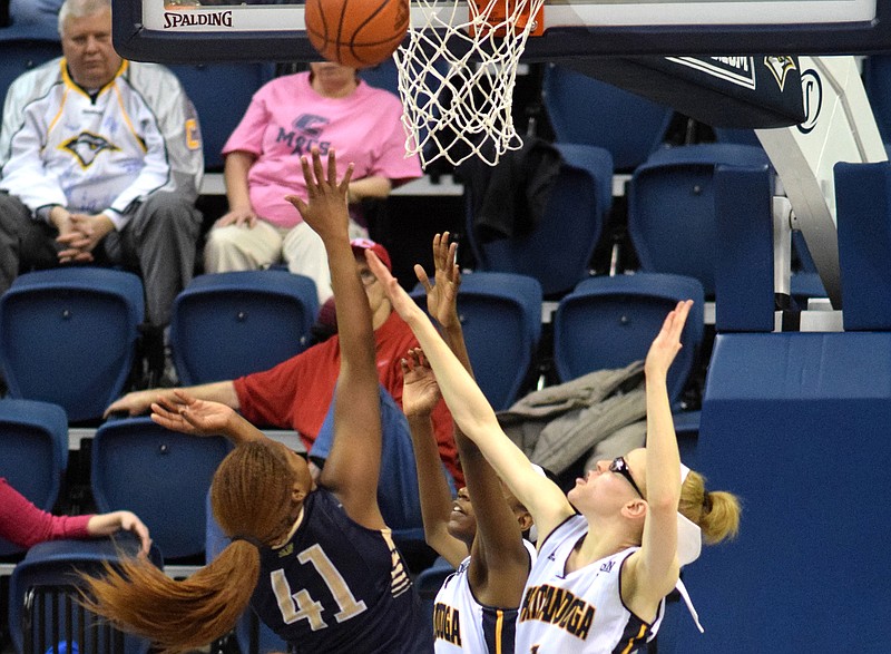 UTC's Jasmine Joyner (3) and Alicia Payne (1) defend against the shot of ETSU's Destiny Mitchell (41). The East Tennessee State University Bucs visited the UTC Mocs in a Southern Conference Basketball game in McKenzie Arena on Saturday. 