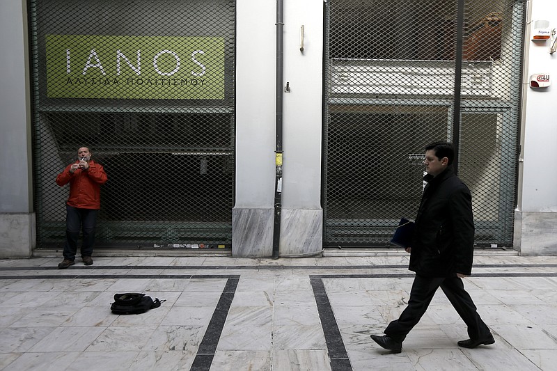 
              A man plays music next to a shuttered shop in a shopping arcade of Athens, on Monday, March 2, 2015. Germany's finance minister Wolfgang Schaeuble said Sunday that he trusts Greece's current government to fulfill the conditions for the bailout deal, but also made clear the country would not receive any further money if it didn't. (AP Photo/Thanassis Stavrakis)
            