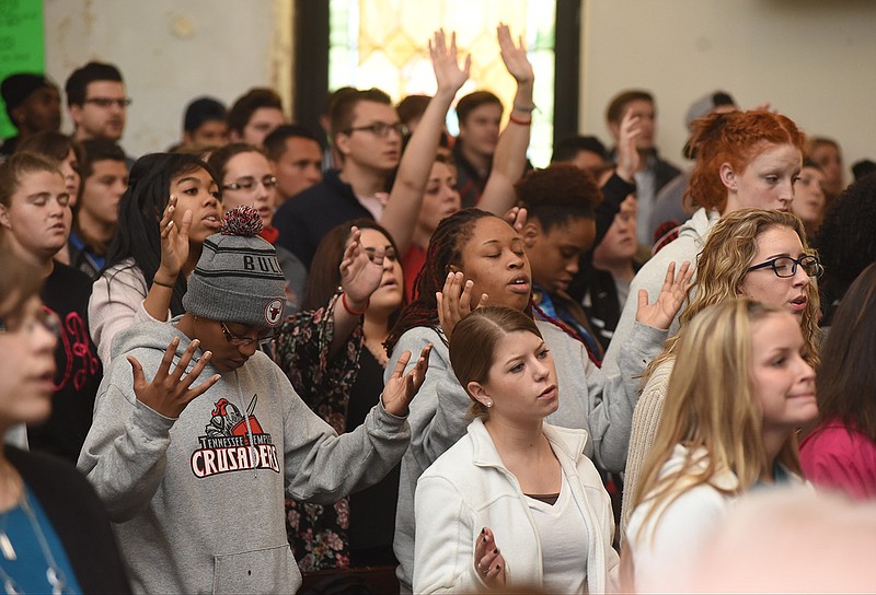 Tennessee Temple University students raise their hands as theysing during worship service Tuesday, Mar. 3, 2015, in Chattanooga, Tenn., after TTU announced that it will close and merge with Piedmont International University at the end of the semester. 