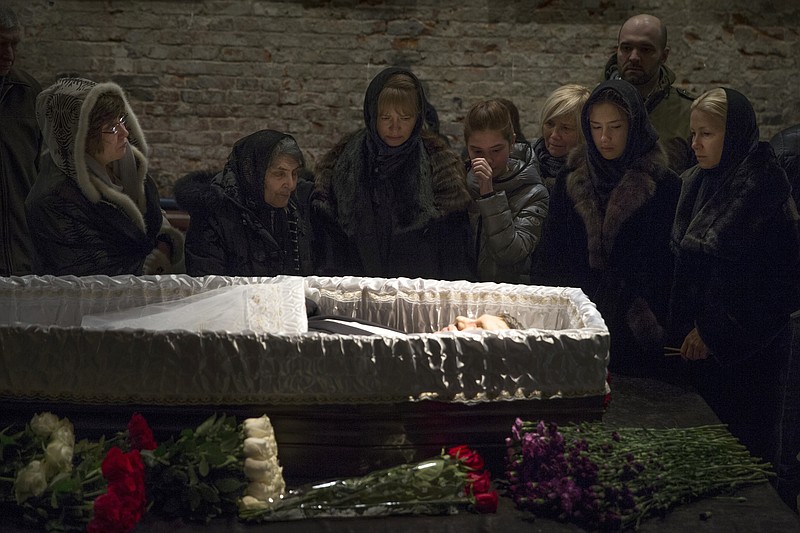 
              Relatives and friends pay their last respects while passing the coffin of Boris Nemtsov, a charismatic Russian opposition leader and sharp critic of President Vladimir Putin, during a farewell ceremony inside the Sakhavov's center in Moscow, Russia, Tuesday, March 3, 2015. Mourners are lining up outside the Moscow human rights center for the funeral of murdered Nemtsov. Western officials have called for Russia to conduct a prompt, thorough, transparent and credible investigation into the slaying. Putin has ordered law enforcement chiefs to personally oversee the probe. (AP Photo/Pavel Golovkin)
            
