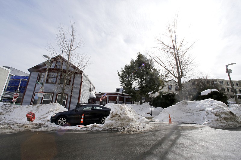 In this Feb. 23, 2015, photo, cones save parking spaces on a neighborhood street in South Boston. Officials typically turn a blind eye to the lawn chairs, orange cones and assorted bric-a-brac Bostonians use to reserve a parking space after clearing it of snow.
