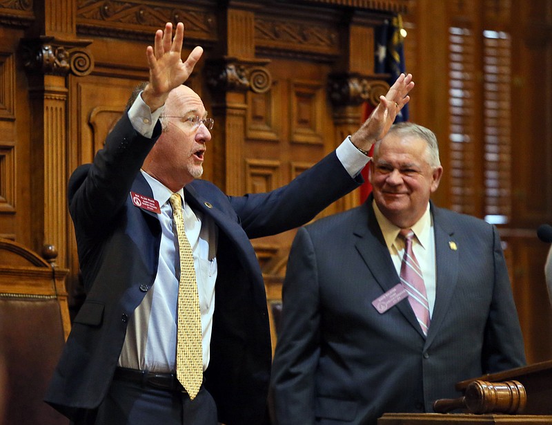 State Rep. Allen Peake, left,, R-Macon, standing with House Speaker David Ralston, acknowledges a standing ovation after the House overwhelmingly passed House Bill 1, Wednesday, Feb. 25, 2015, in Atlanta, to legalize cannabis oil for the treatment of nine major health problems, including sickle cell disease.