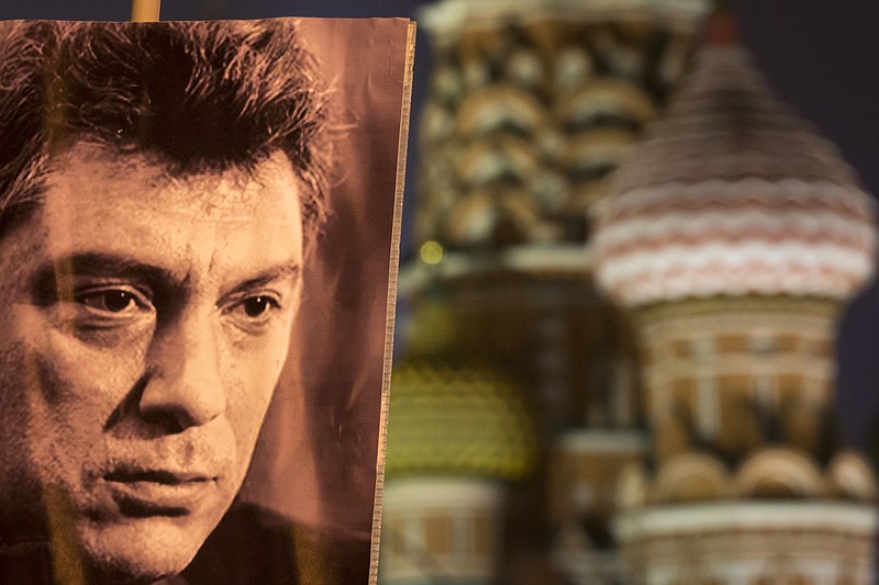 A portrait of Boris Nemtsov, a charismatic Russian opposition leader and sharp critic of President Vladimir Putin, who was gunned down on Friday, Feb. 27, 2015, near the Kremlin, seen with St. Basil's Cathedral is in the background in Moscow, Russia, Monday, March 2, 2015.
