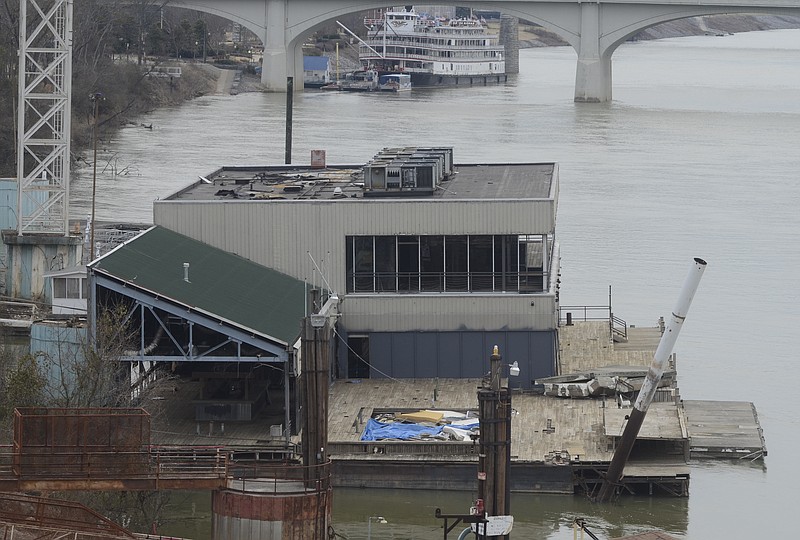 A former restaurant barge, purchased by Allen Casey and docked at his property on the north shore of the Tennessee River for several years, is seen Wednesday from the Olgiati Bridge. The Delta Queen, docked at Coolidge Park, is seen in the background.