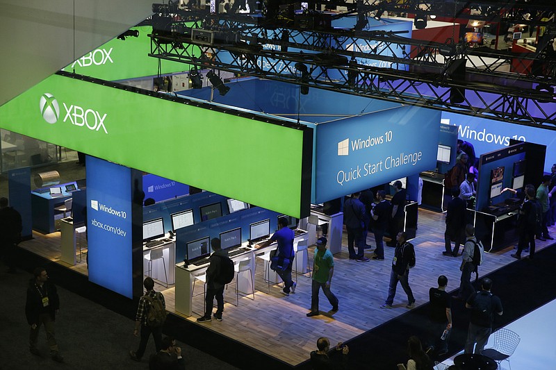 
              People walk through the Microsoft booth at the Game Developers Conference, Wednesday, March 4, 2015, in San Francisco. (AP Photo/Eric Risberg)
            