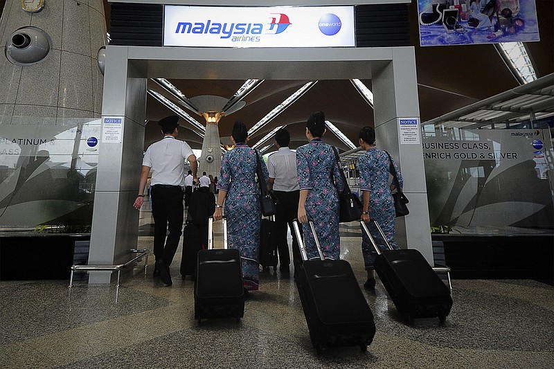 
              FILE - In this April 10, 2014, file photo, a Malaysia Airlines crew walks into a check in area at Kuala Lumpur International Airport in Sepang, Malaysia. New Malaysia Airlines CEO, Christoph Mueller, 52, comes to the post fresh from a stint reviving Ireland’s Aer Lingus. Mueller will be the first foreigner to head the Malaysian state-owned company. Analysts say he’s an industry veteran “battle hardened” from his work carrying out corporate restructurings at other state-owned airlines, including failed Belgian carrier Sabena.  (AP Photo/Joshua Paul, File)
            