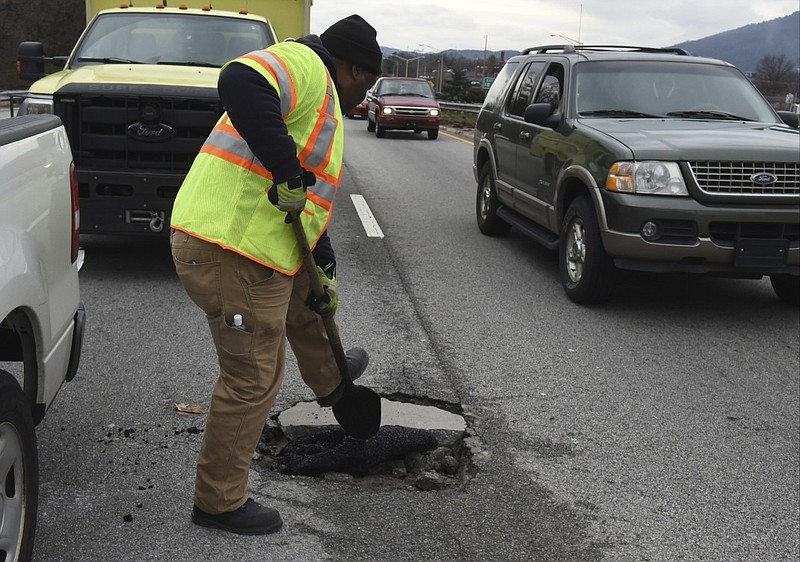 Joseph Webb, TDOT supervisor for Hamilton County, puts a temporary patch on a pothole on Highway 27 northbound in between the MLK Boulevard exit and the Fourth Street exit Thursday, Mar. 5, 2015, in Chattanooga, Tenn.