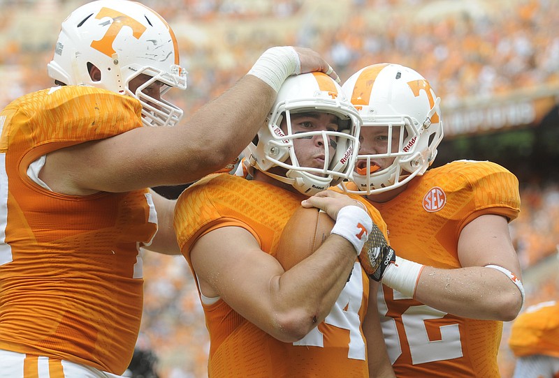 UT's Kyler Kerbyson, left, and Ethan Wolf celebrate with Justin Worley, center, after his touchdown carry against Arkansas State in this Sept. 6, 2014, file photo.