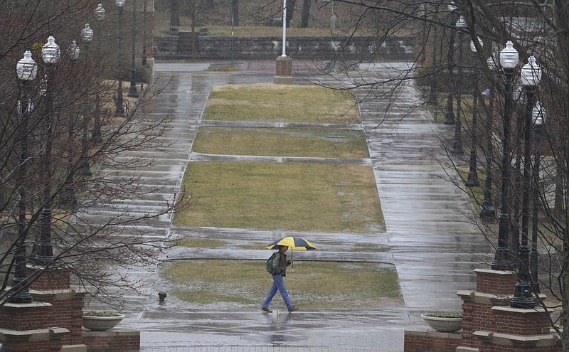 A pedestrian walks through the University of Tennessee at Chattanooga's campus as temperatures hover in the mid 30's and rain falls in the Tennessee Valley on Thursday, March 5, 2015.