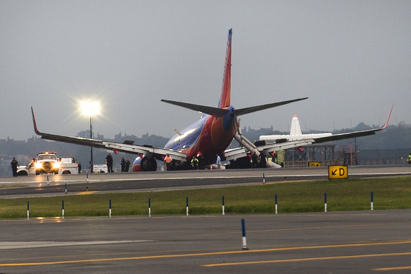 
              FILE - In this July 22, 2013 file photo, a Southwest Airlines jet rests on the tarmac after what officials say was a nose gear collapse during a landing at LaGuardia Airport. Sixteen passengers and crew members were hurt. Southwest fired the captain and required additional training for the co-pilot. (AP Photo/John Minchillo, File)
            