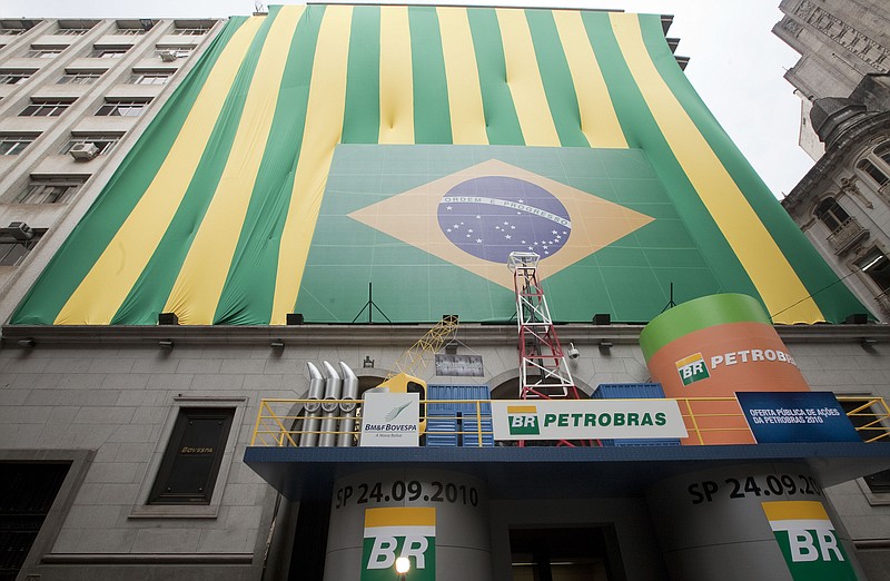 
              FILE - In this Sept. 24, 2010 file photo, a Brazilian flag and the word "Petrobras" decorate the entrance of the stock market building on the first day of trading in Sao Paulo, Brazil. Brazil’s Attorney General Rodrigo asked the nation’s Supreme Court on Tuesday, March 3, 2015 for permission to investigate top political figures for alleged involvement in a kickback scheme at the state-run oil company Petrobras, which prosecutors say is the country’s largest corruption scandal yet uncovered. (AP Photo/Andre Penner, File)
            