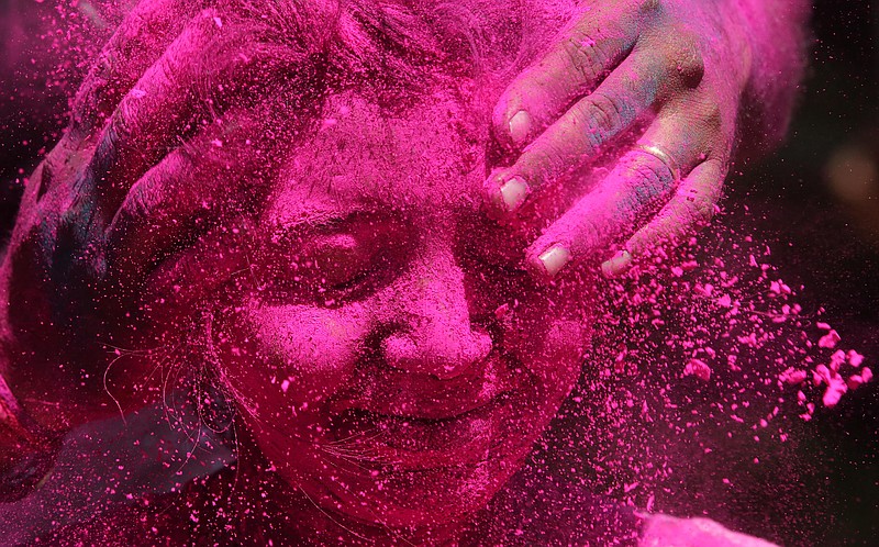 
              An Indian woman shuts her eyes as colored powder is smeared on her face during celebrations marking Holi, the Hindu festival of colors, in Mumbai, India, Friday, March 6, 2015. Holi, India's joyful and colorful celebration of the arrival of spring along with several religious myths and legends, has long ceased to be only a Hindu festival. The streets and lanes across most of India turn into a large playground where people of all faiths throw colored powder and water at each other. (AP Photo/Rajanish Kakade)
            