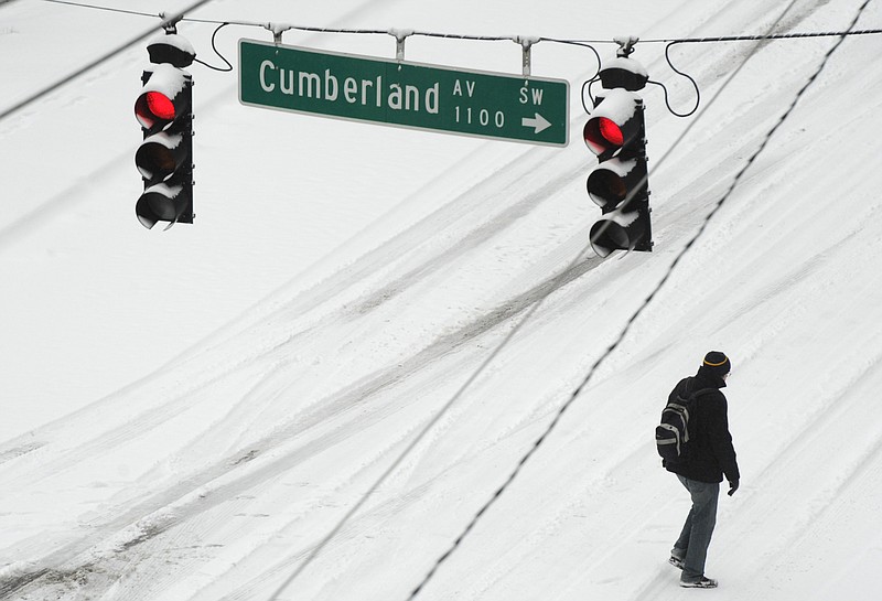 A pedestrian makes his way up Cumberland Ave. towards the University of Tennessee following overnight snows on Tuesday, Feb. 24, 2015, in Knoxville.