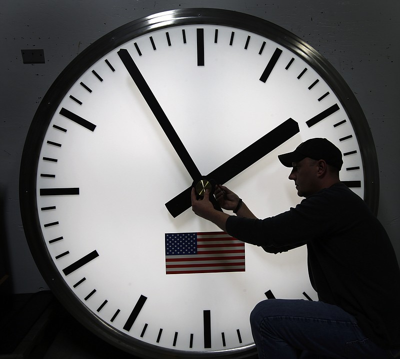 
              FILE - Dave LeMote uses an allen wrench to adjust hands on a stainless steel tower clock at Electric Time Company, Inc. in Medfield, Mass., in this March 7, 2014 file photo. Most Americans will set their clocks 60 minutes forward before heading to bed Saturday night March 7, 2015, but daylight saving time officially starts Sunday at 2 a.m. local time (0700GMT). (AP Photo/Elise Amendola, File)
            