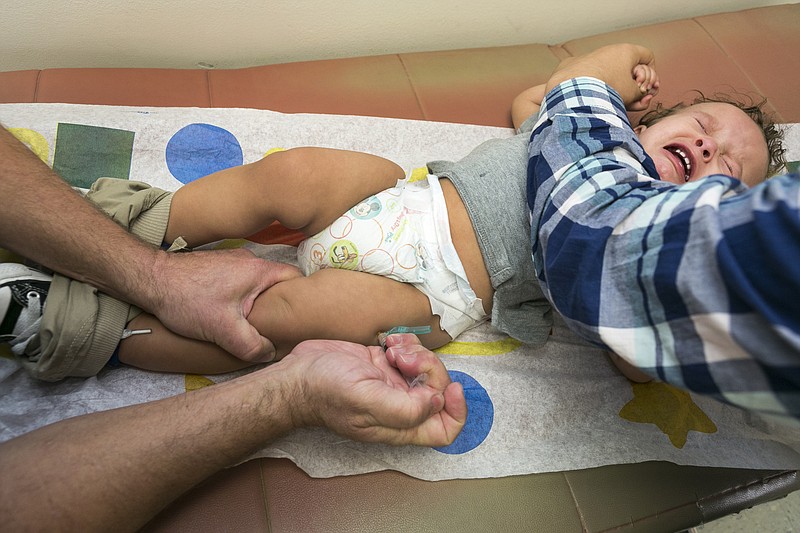 Pediatrician Dr. Charles Goodman vaccinates 1 year- old Cameron Fierro with the measles-mumps-rubella vaccine, or MMR vaccine at his practice in Northridge, Calif., in this Jan. 29, 2015, file photo.