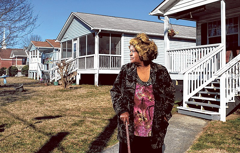 Alma Johnson stands Saturday outside of her home, which was built by Habitat for Humanity, along a row of other Habitat homes on Dodson Avenue.