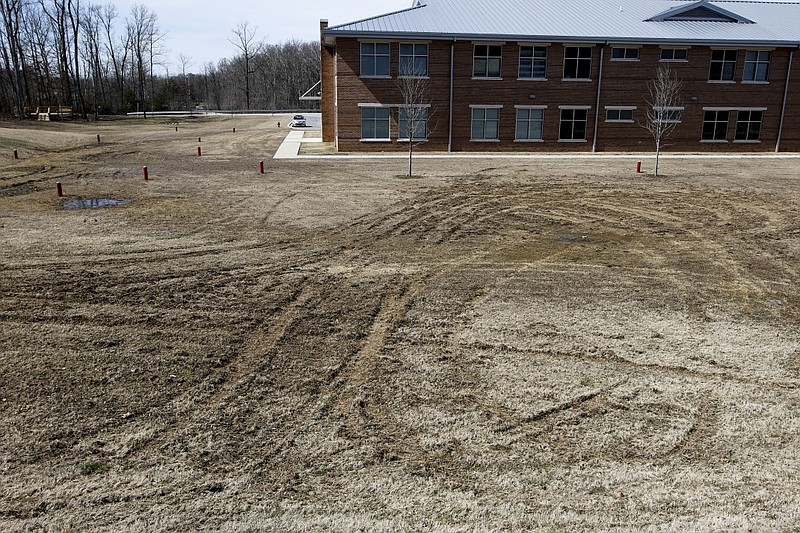 Tire tracks are visible in the grassy "quad" area Sunday, March 8, 2015, after vandals damaged athletic and facility fields at Signal Mountain Middle High School in Signal Mountain, Tenn.