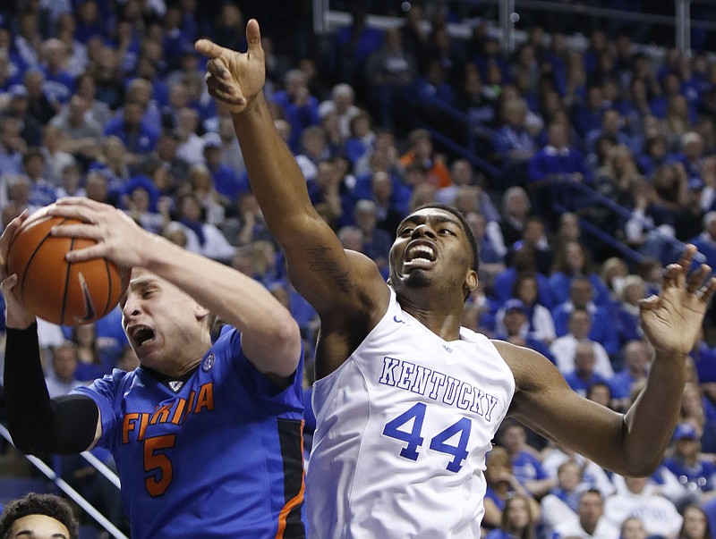 Florida's Alex Murphy (5) pulls down a rebound next to Kentucky's Dakari Johnson (44) during the first half of an NCAA college basketball game Saturday, March 7, 2015, in Lexington, Ky. (AP Photo/James Crisp)