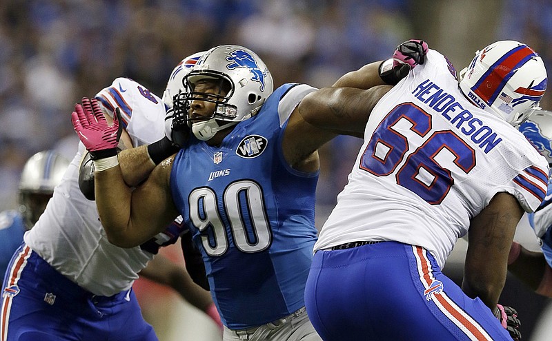 In this Oct. 5, 2014, file photo, Detroit Lions defensive tackle Ndamukong Suh (90) works his way through the Buffalo Bills offensive line during the first half of an NFL football game in Detroit. 