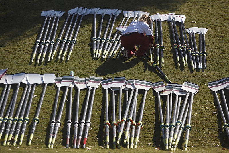 Megan Patrick, assistant coach for the University of Alabama's women's varsity rowing team, arranges oars on a hill at Ross's Landing in preparation of the 2012 Head of the Hooch meet.