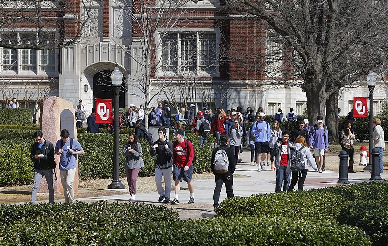 
              People walk on the Oval at the University of Oklahoma in Norman, Okla., Tuesday, March 10, 2015. Two students have been expelled from the university following an incident in which members of a fraternity were caught on video chanting a racial slur. (AP Photo/Sue Ogrocki)
            