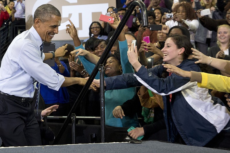 Students reach out for President Barack Obama as he arrives to speak at Georgia Tech in Atlanta on Tuesday, March 10, 2015, about his plan to clamp down on the private companies that service federal student debt. 