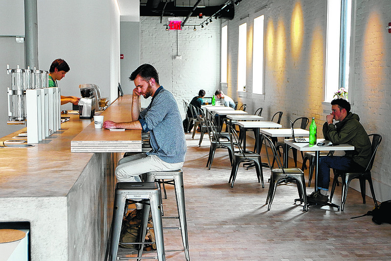 Christian Scharf sits at the bar as he drinks coffee Wednesday, March 11, 2015, at newly opened Revelator Coffee Co. in Chattanooga, Tenn. The coffee shop opened on the ground floor of the Nautilus Building at the corner of Frazier Avenue and Market Street.