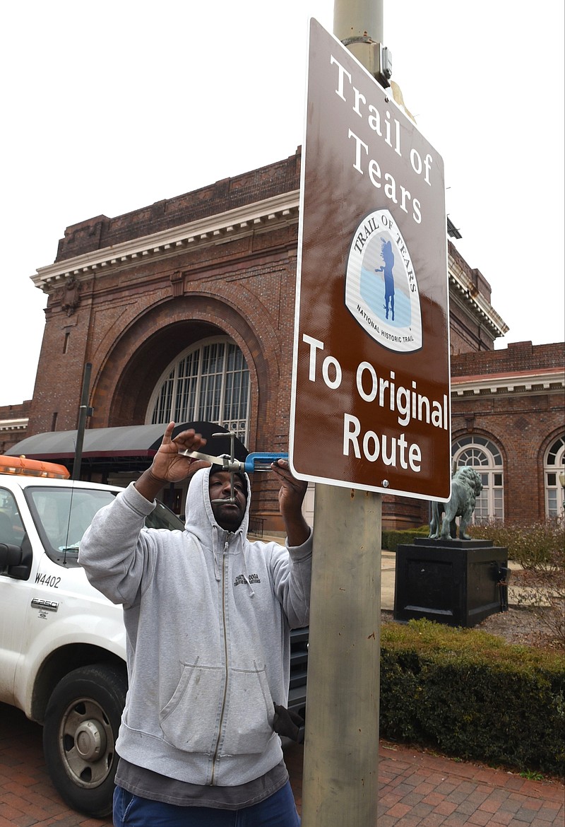 Carlton Dupree of the City of Chattanooga's Traffic Operations department installs a Trail of Tears National Historic Trail sign in front of the Chattanooga Choo Choo on Market Street.