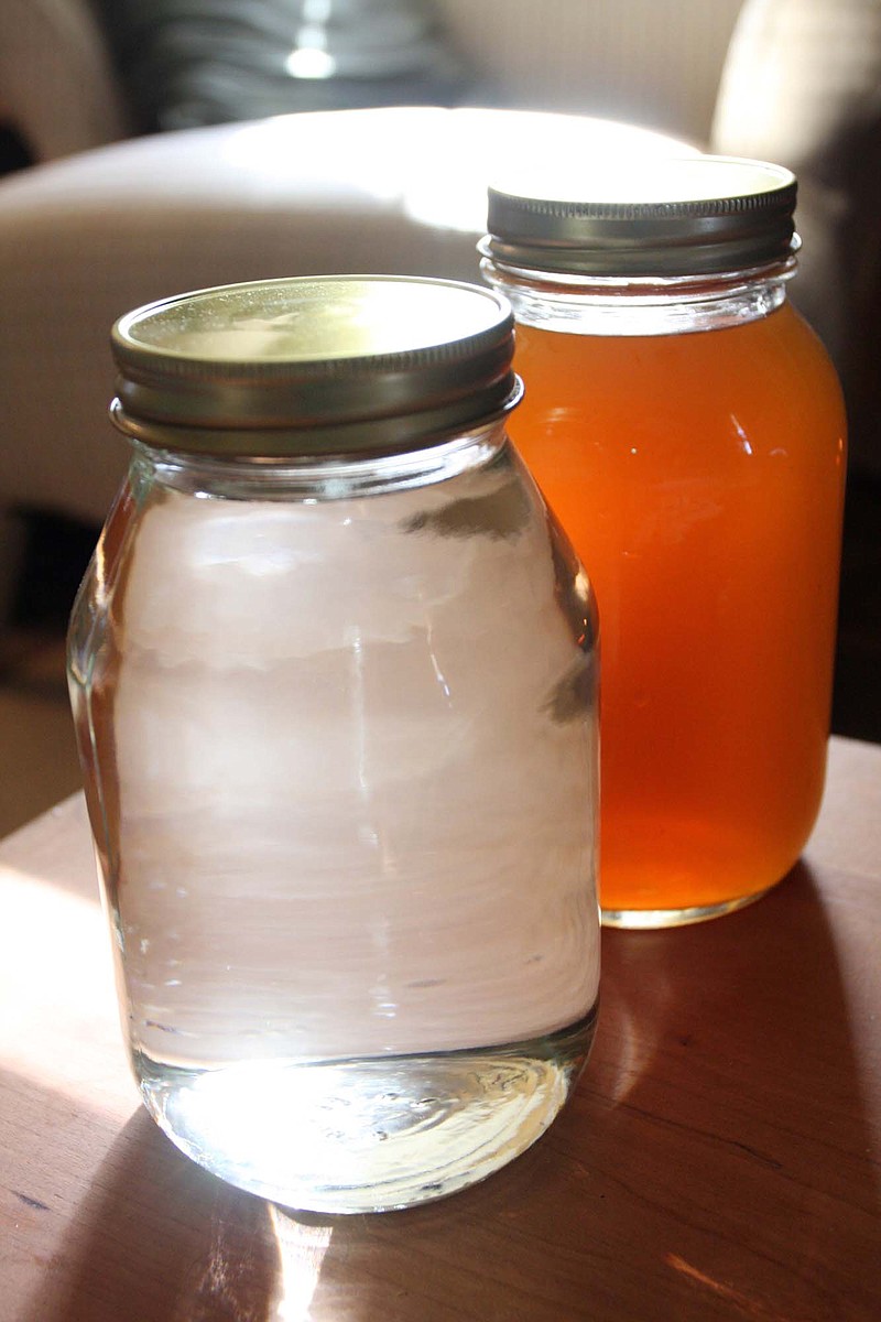 Pictured are two jars of moonshine. The darker variety is called "apple pie, "