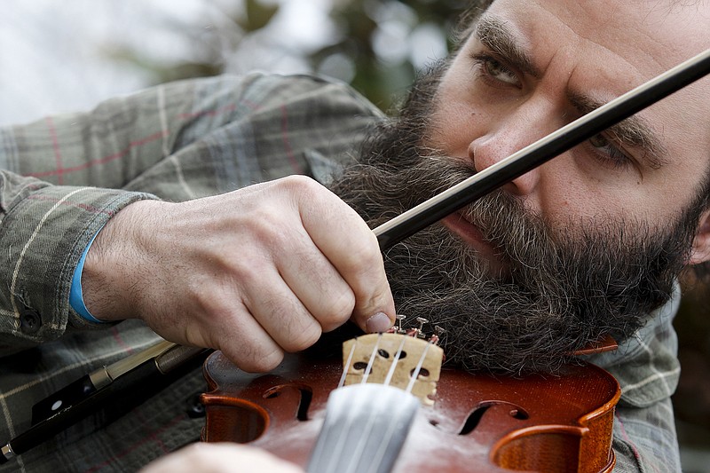 Philip Stewart tunes his violin Saturday, March 14, 2015, at the 6th Annual Great Southern Old Time Fiddlers Convention at Lindsay Street Hall in Chattanooga. The convention draws musicians from across the region to play together and compete in musical competitions.