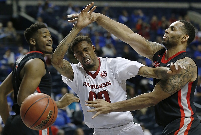 Arkansas guard Rashad Madden (00) runs into the defense of Georgia forward Marcus Thornton, right and Georgia forward/center Yante Maten (1) during the second half of an NCAA college basketball game in the semifinal round of the Southeastern Conference tournament, Saturday, March 14, 2015, in Nashville.