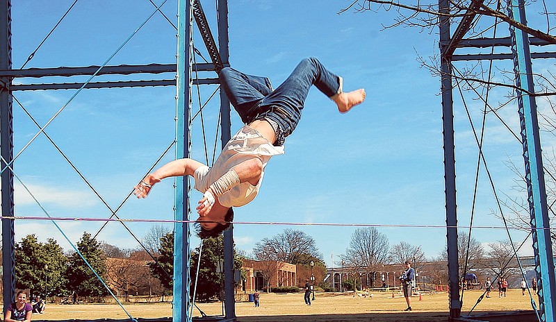 Roy Tyson does a flip on a slackline set up in Coolidge Park.